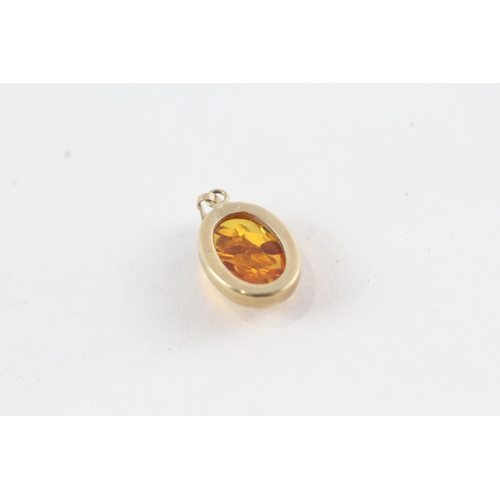 100 - 2 x 9ct gold topaz & processed amber pendants (3.9g)