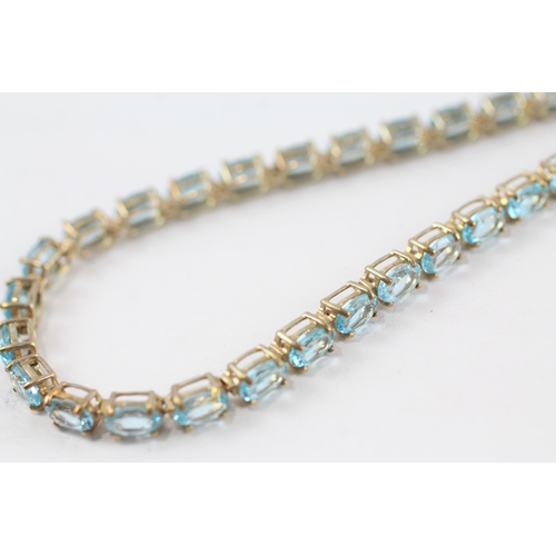 195 - 9ct gold blue topaz bracelet (9g)