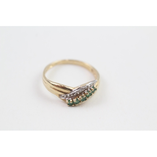 111 - 9ct gold diamond & emerald crossover ring (1.8g)