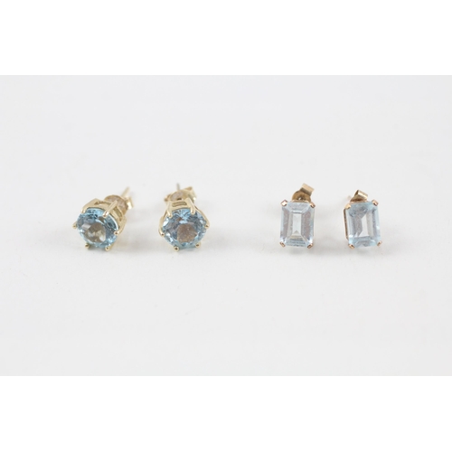 43 - 2x 9ct gold blue topaz stud earrings with scroll backs (2.6g)