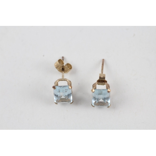 43 - 2x 9ct gold blue topaz stud earrings with scroll backs (2.6g)