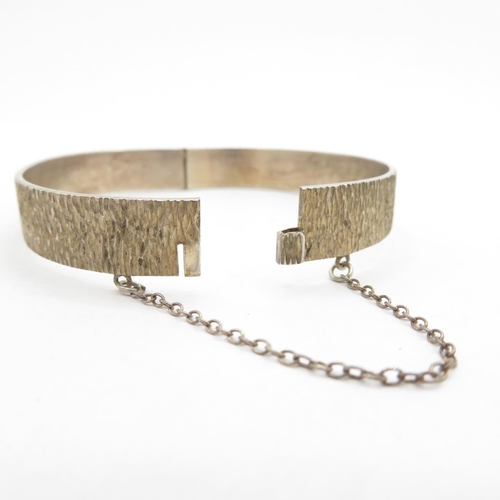 199 - Silver HM bangle with safety chain in bark effect  20.8g