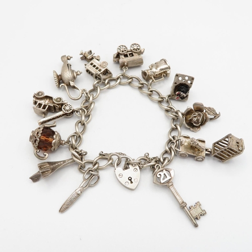 Silver charm bracelet with assorted charms - some articulated  57.2g