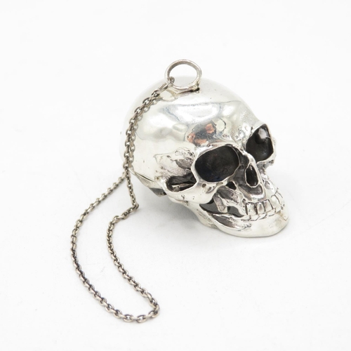Extremely fine detailed articulated Memento Mori human skull in sterling silver with hinged bottom jaw and locking pin.  Skull has hanging safety chain to wear as fob or pendant  (33.3g) 40mm long.  In excellent condition