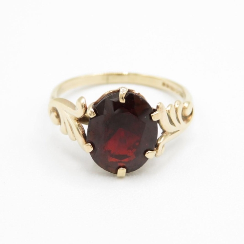 9ct gold oval cut garnet dress ring with patterned shoulders (1.9g) Size  L