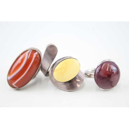 Three modernist statement cocktail rings one set with amber (40g) Size N, O, R