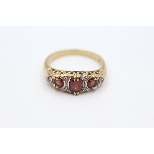 27 - 9ct gold garnet three stone with diamond accent Size  P   - 3.4 g