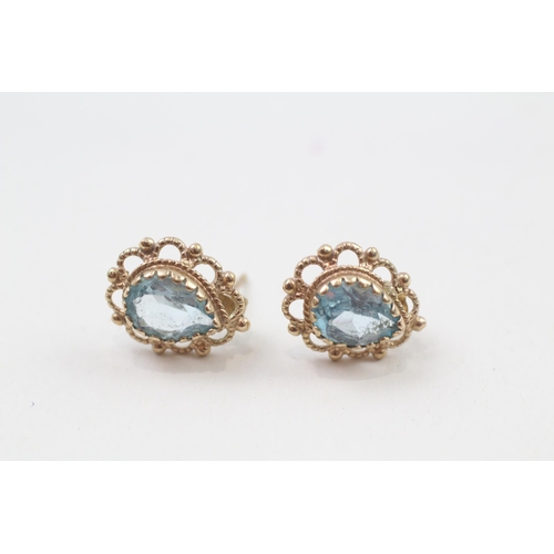 69 - 9ct gold pear cut blue topaz stud earrings with scroll backs (2.1g)