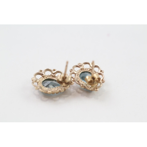 69 - 9ct gold pear cut blue topaz stud earrings with scroll backs (2.1g)