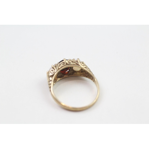 87 - 9ct gold vintage garnet & opal three stone ring with a scroll pattered gallery (3g) Size  P