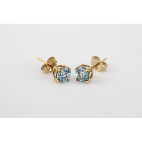 97 - 9ct gold blue topaz stud earrings with scroll backs (0.8g)