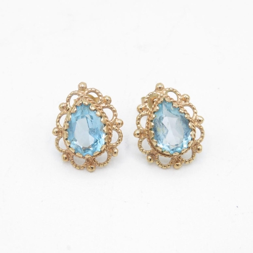 69 - 9ct gold pear cut blue topaz stud earrings with scroll backs (2.1g)