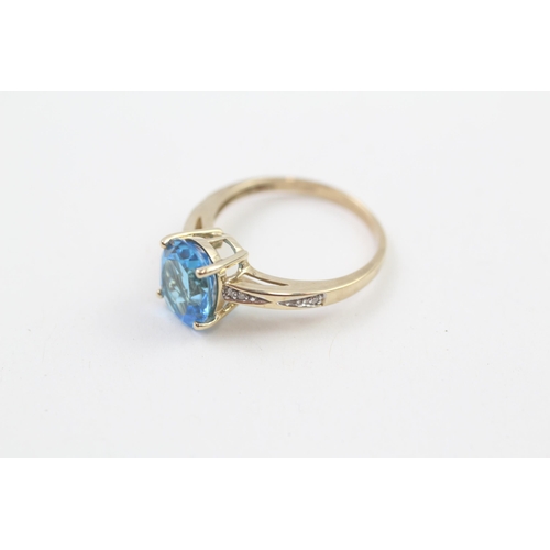 208 - 9ct gold oval cut blue topaz & diamond ring, claw set (2.5g) Size  N