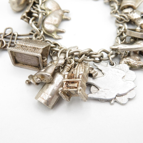 407 - HM silver charm bracelet with assorted charms, some articulated.  49.7g