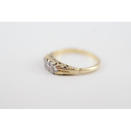 255 - 18ct gold vintage diamond three stone ring with scroll patterned gallery 3.1g Size L 1/2