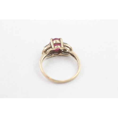 127 - 9ct gold diamond accented heart detailed oval cut ruby set ring (2.2g) Size L 1/2