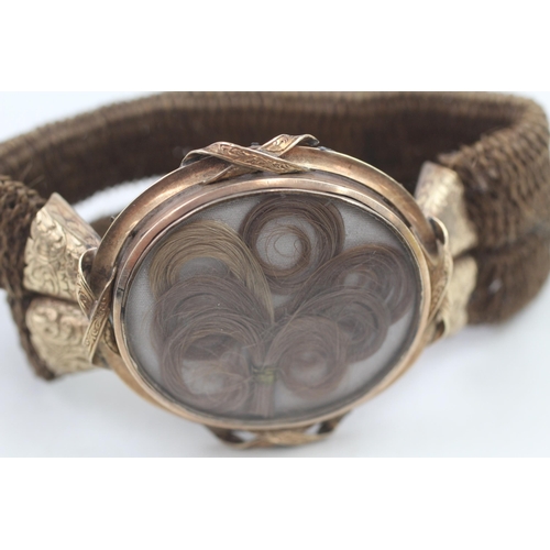 188 - 10ct gold framed antique silk backed hair work locket on a woven hairwork bracelet (16.2g)