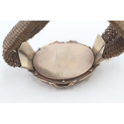 188 - 10ct gold framed antique silk backed hair work locket on a woven hairwork bracelet (16.2g)