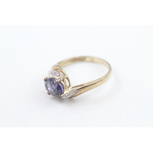 212 - 9ct gold diamond accented oval cut iolite set bypass ring (3g) Size S