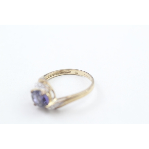 212 - 9ct gold diamond accented oval cut iolite set bypass ring (3g) Size S