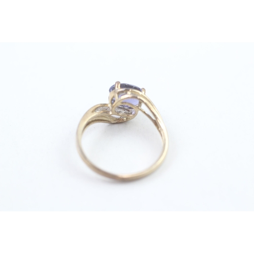 212 - 9ct gold diamond accented oval cut iolite set bypass ring (3g) Size S