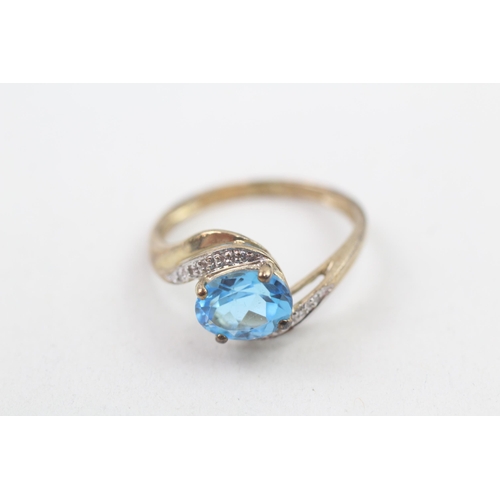 214 - 9ct gold diamond accented blue topaz set bypass ring (2.7g) Size R 1/2