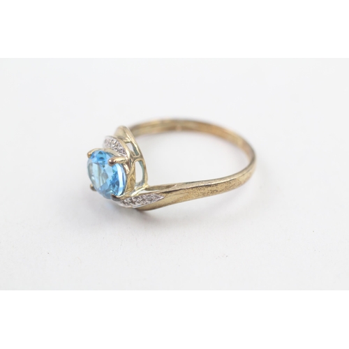 214 - 9ct gold diamond accented blue topaz set bypass ring (2.7g) Size R 1/2