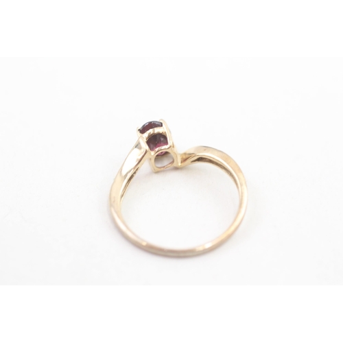 215 - 9ct gold diamond accented garnet set bypass ring (1.7g) Size N