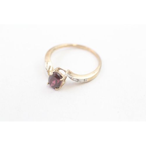 215 - 9ct gold diamond accented garnet set bypass ring (1.7g) Size N