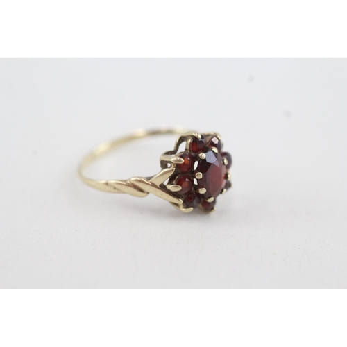 82 - 9ct gold garnet floral cluster ring with twisted shank (2g) Size P