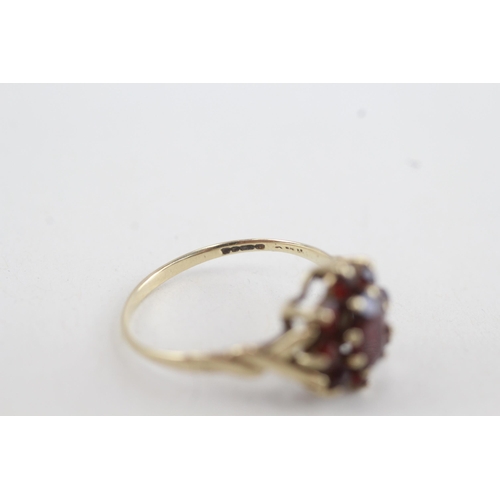 82 - 9ct gold garnet floral cluster ring with twisted shank (2g) Size P