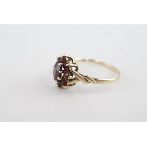 82 - 9ct gold garnet floral cluster ring with twisted shank (2g) Size P