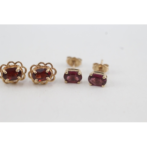 49 - 2x 9ct gold oval cut garnet stud earrings with scroll backs (1.8g)