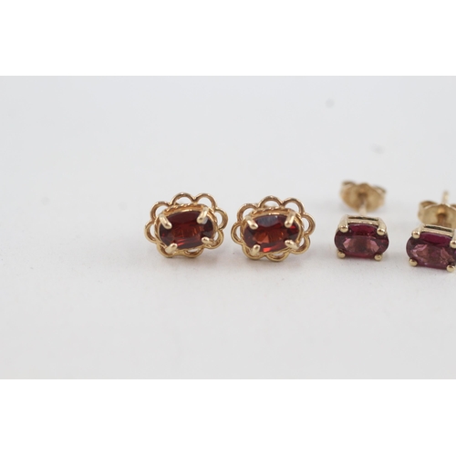 49 - 2x 9ct gold oval cut garnet stud earrings with scroll backs (1.8g)
