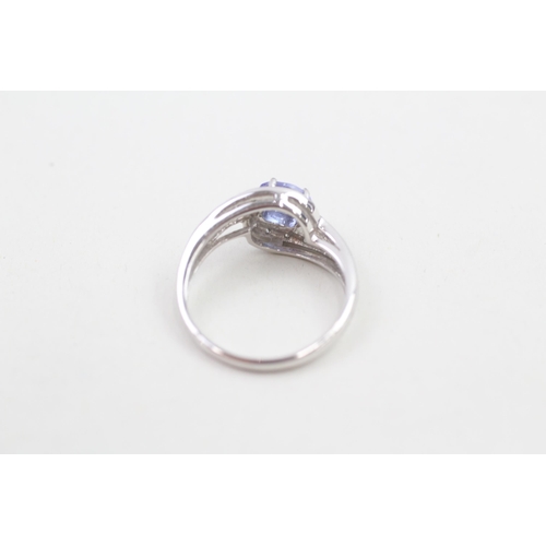91 - 9ct white gold diamond accented tanzanite set bypass dress ring (3g) Size  N