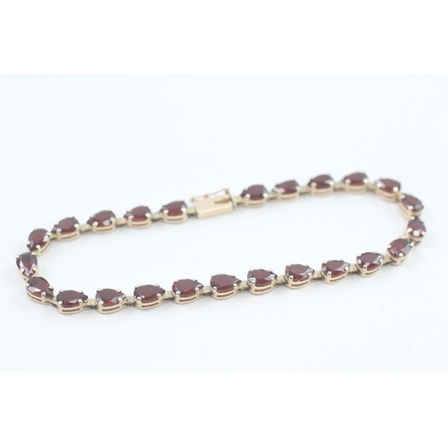 17 - 9ct gold pear cut garnet line bracelet, claw set (5.9g)