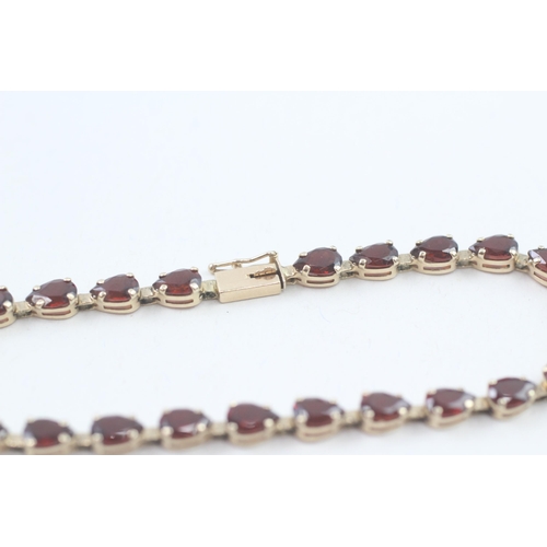 17 - 9ct gold pear cut garnet line bracelet, claw set (5.9g)