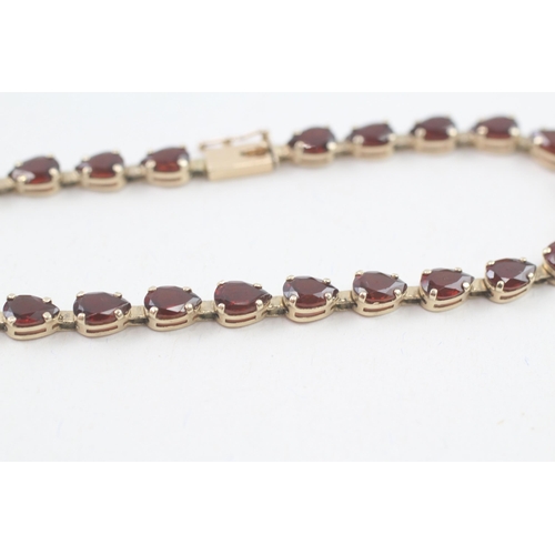 17 - 9ct gold pear cut garnet line bracelet, claw set (5.9g)