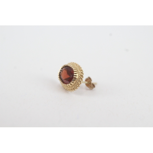 49 - 9ct gold oval garnet single stone stud earrings (2.4g)