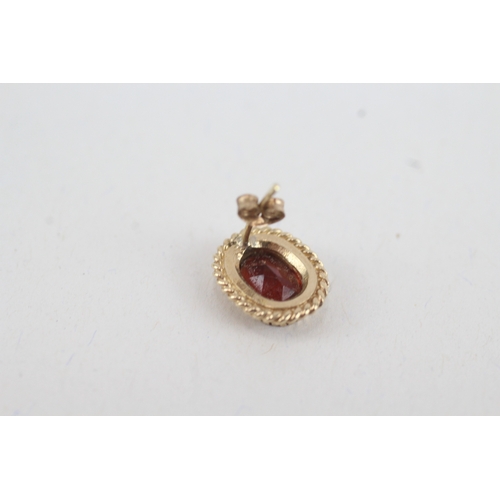 49 - 9ct gold oval garnet single stone stud earrings (2.4g)