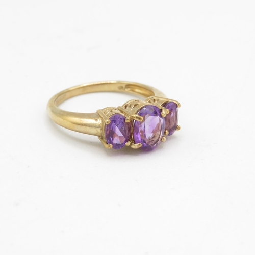 131 - 9ct gold amethyst three stone ring (3.4g) Size  N 1/2