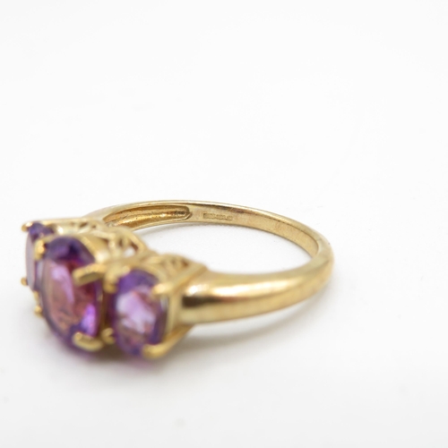 131 - 9ct gold amethyst three stone ring (3.4g) Size  N 1/2