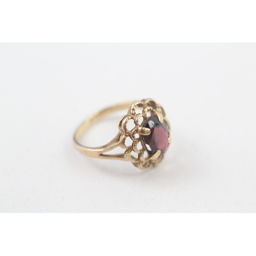 106 - 10kt gold floral surround garnet set dress ring (2.2g) Size  I