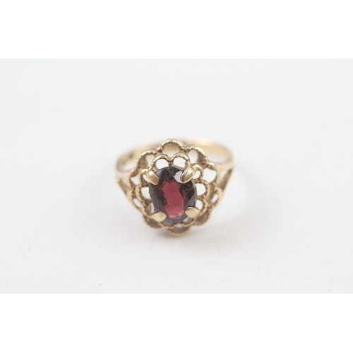 106 - 10kt gold floral surround garnet set dress ring (2.2g) Size  I