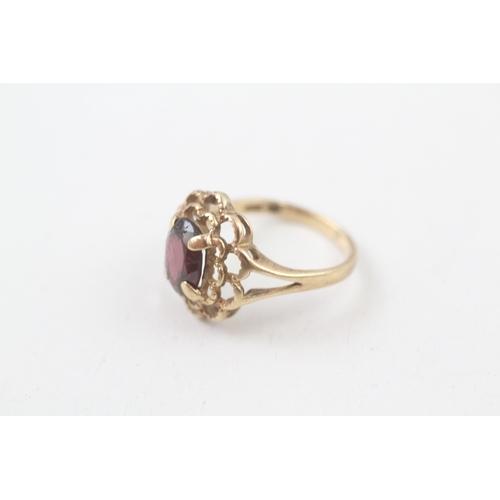 106 - 10kt gold floral surround garnet set dress ring (2.2g) Size  I