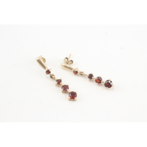 117 - 9ct gold graduated garnet drop earrings with scroll backs (1.9g)