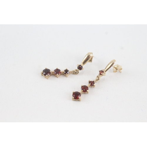 117 - 9ct gold graduated garnet drop earrings with scroll backs (1.9g)