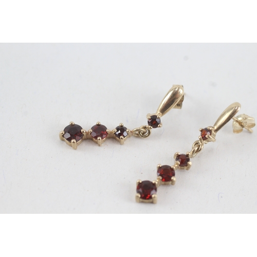 117 - 9ct gold graduated garnet drop earrings with scroll backs (1.9g)