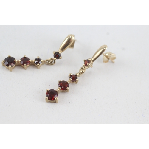 117 - 9ct gold graduated garnet drop earrings with scroll backs (1.9g)