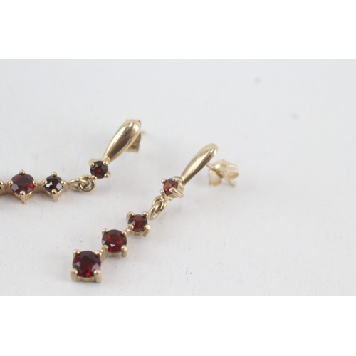 117 - 9ct gold graduated garnet drop earrings with scroll backs (1.9g)